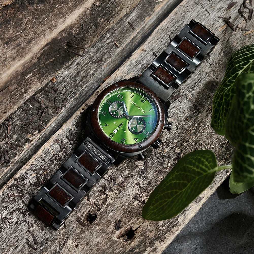 A wristwatch with a green dial and dark brown wood-tone accents on a weathered wooden surface, styled with a green leaf in the foreground.