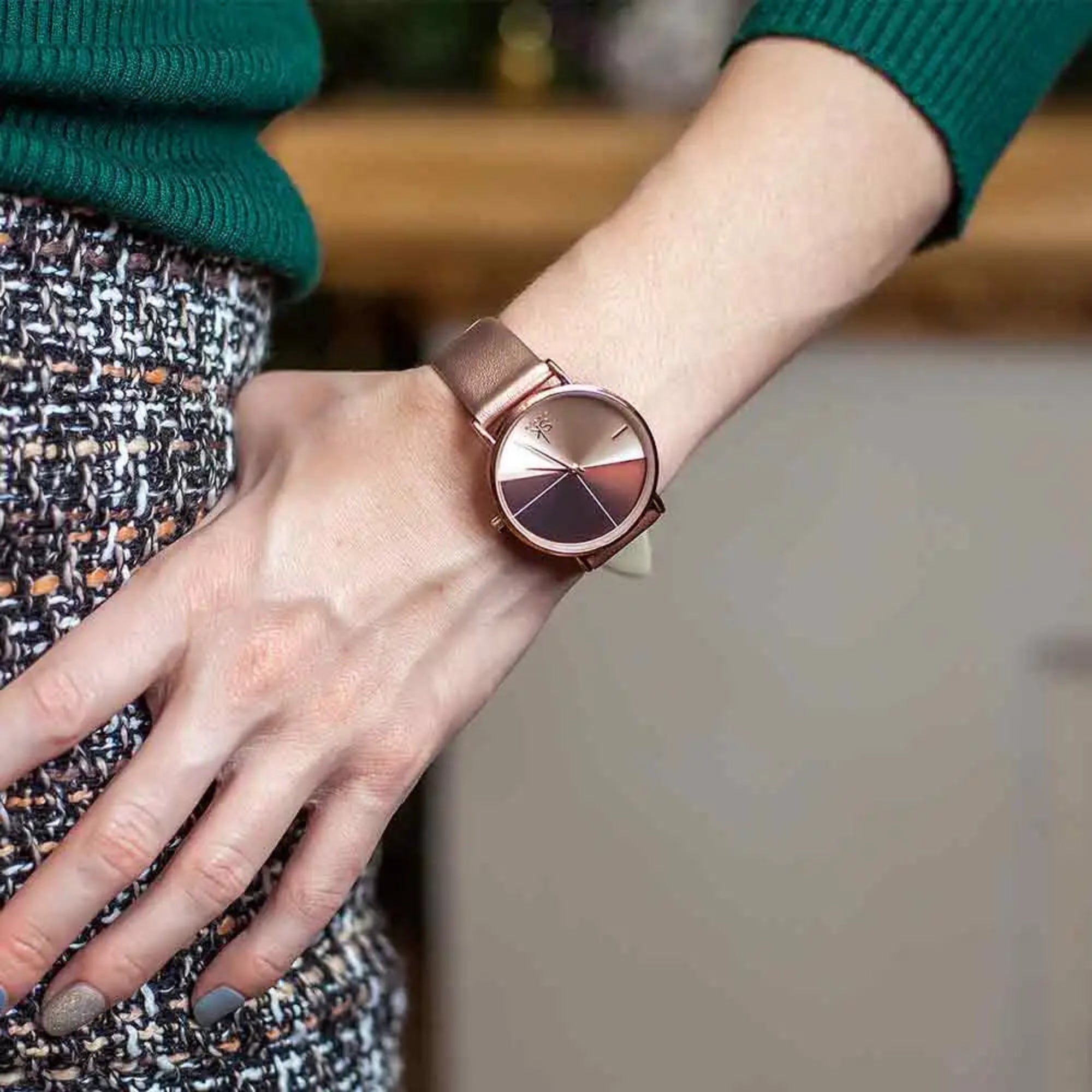 Rose gold watch on a wrist with a blurred background