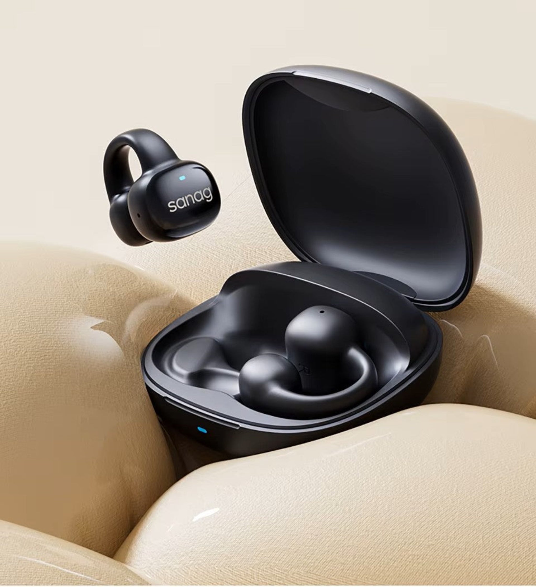 Black wireless earbuds with charging case on a beige surface