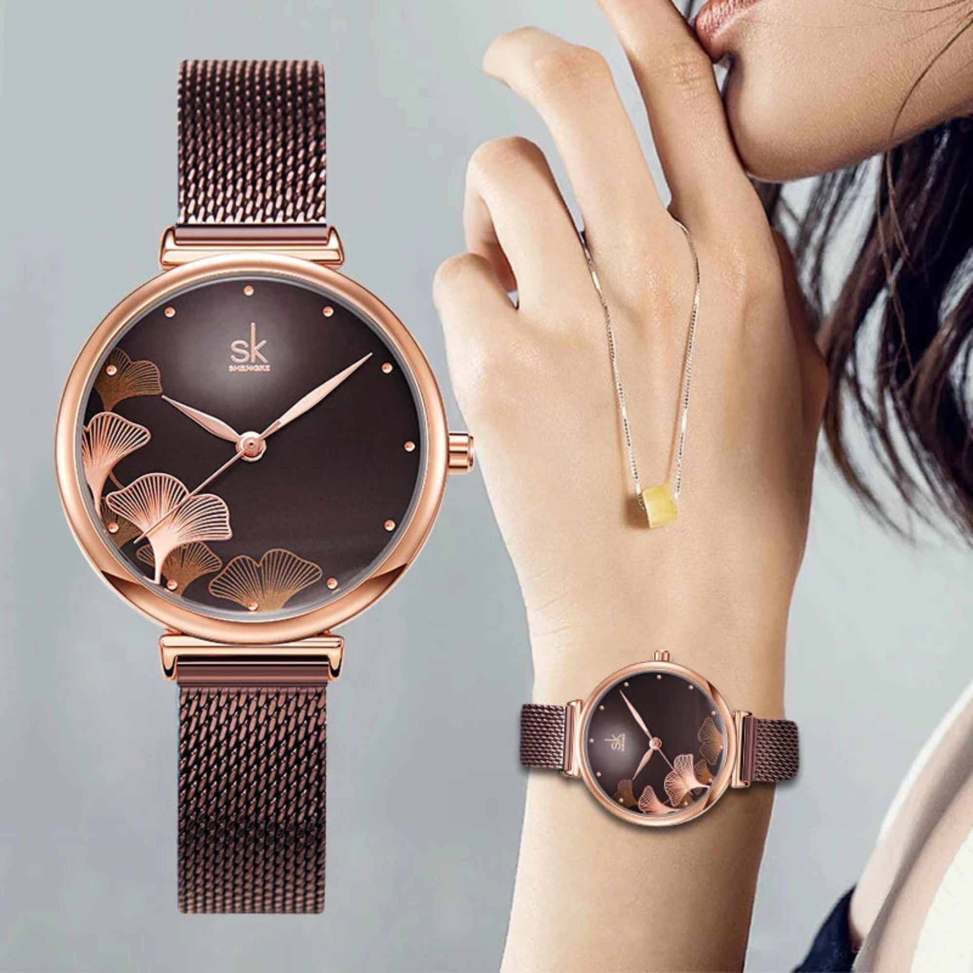 A woman's wristwatch with a brown mesh band and a rose gold case, featuring a floral pattern on the dial.