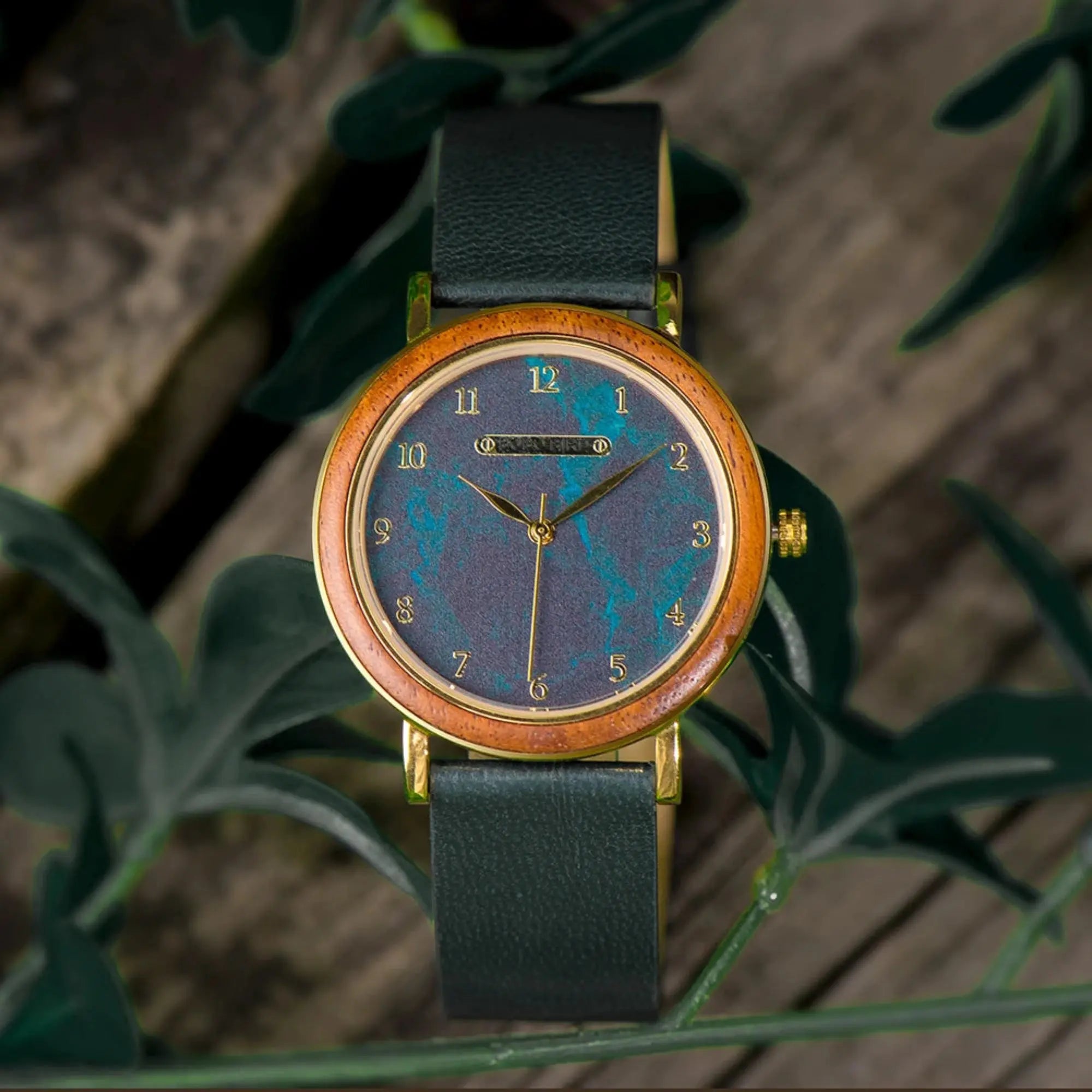 Watch with a wooden case and blue face on a green leafy background