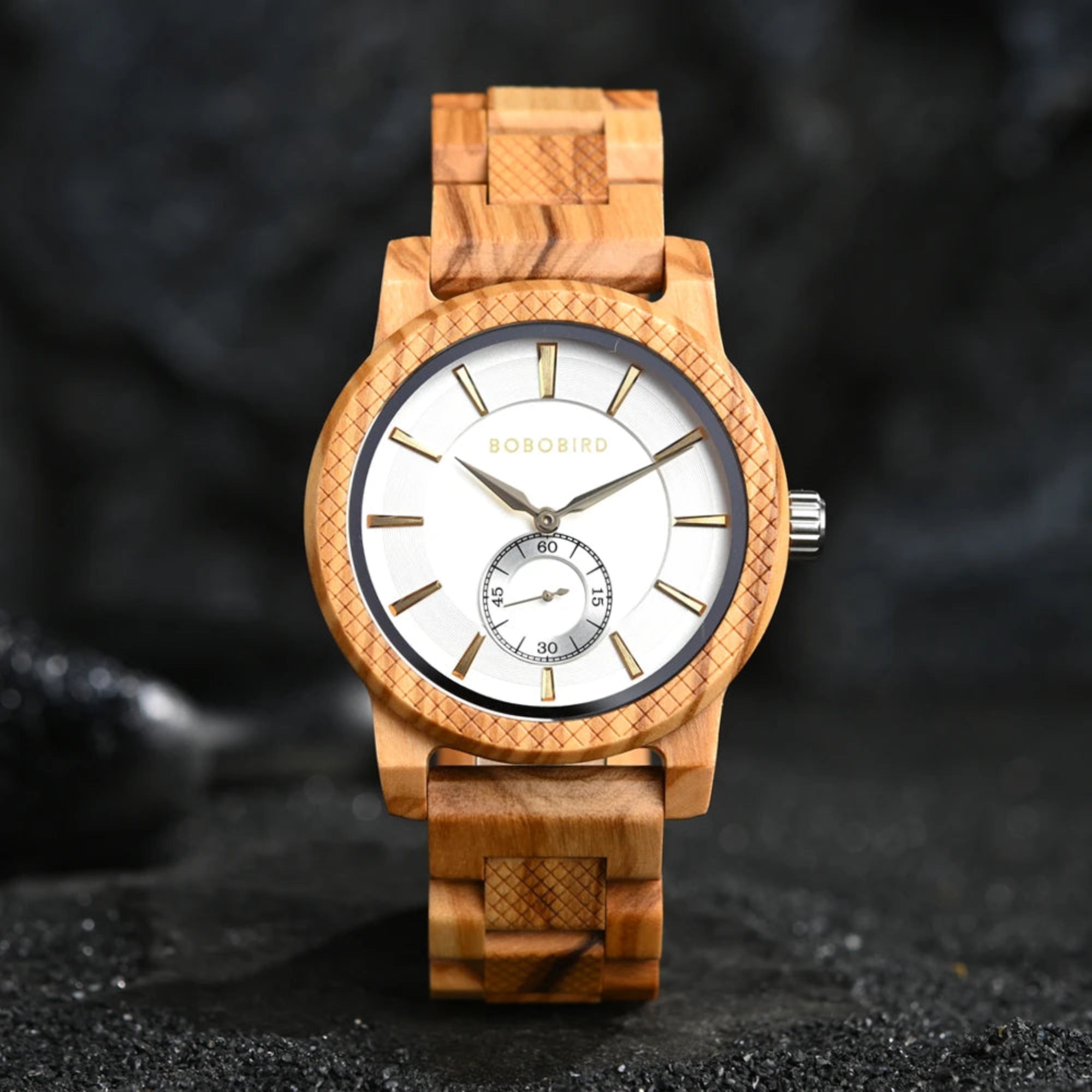 A watch with a green dial and wooden strap, featuring a patterned bezel and analog hands.