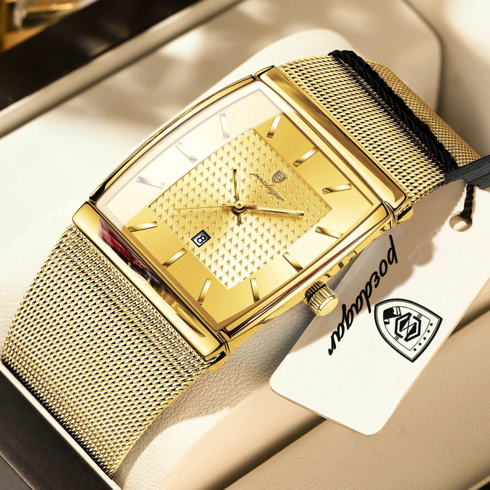 Gold watch with a mesh band on a white background, featuring a brand tag.