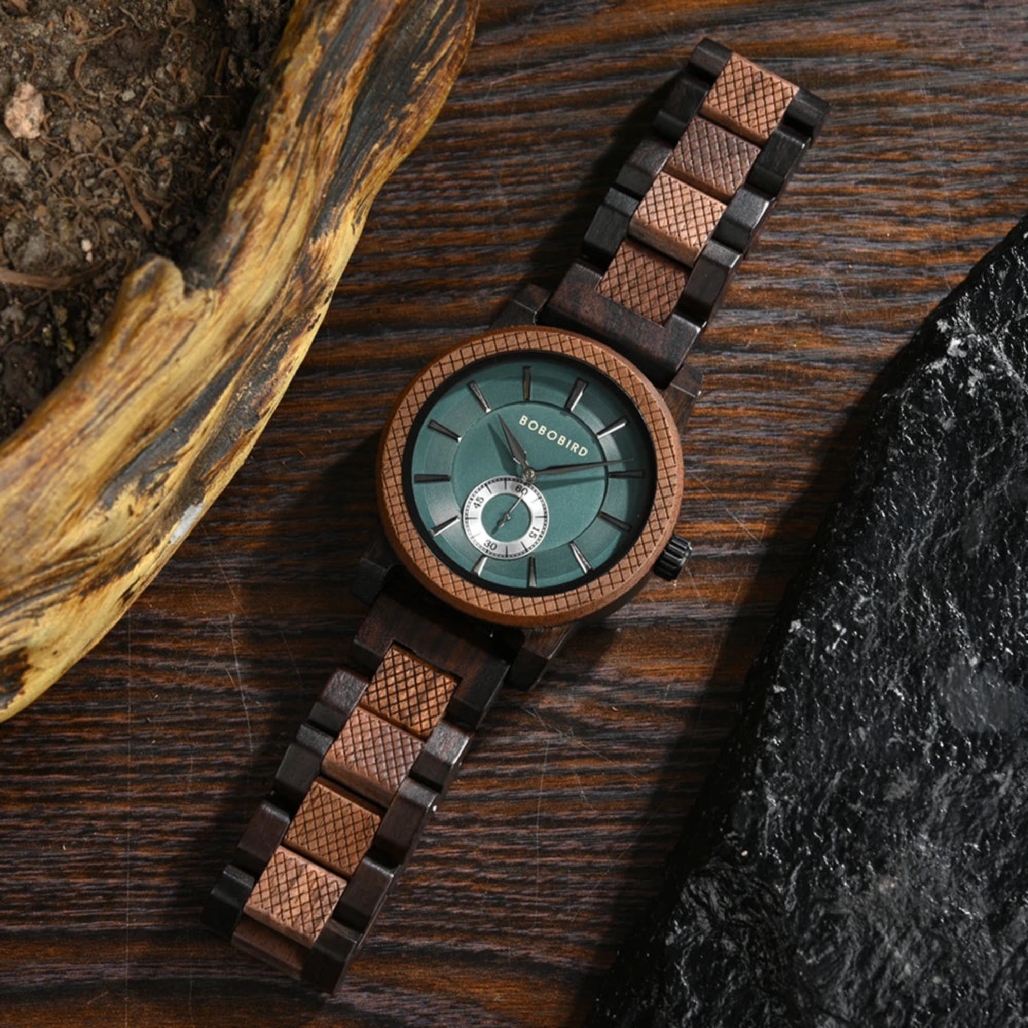 Wooden watch with a green face on a dark wooden surface