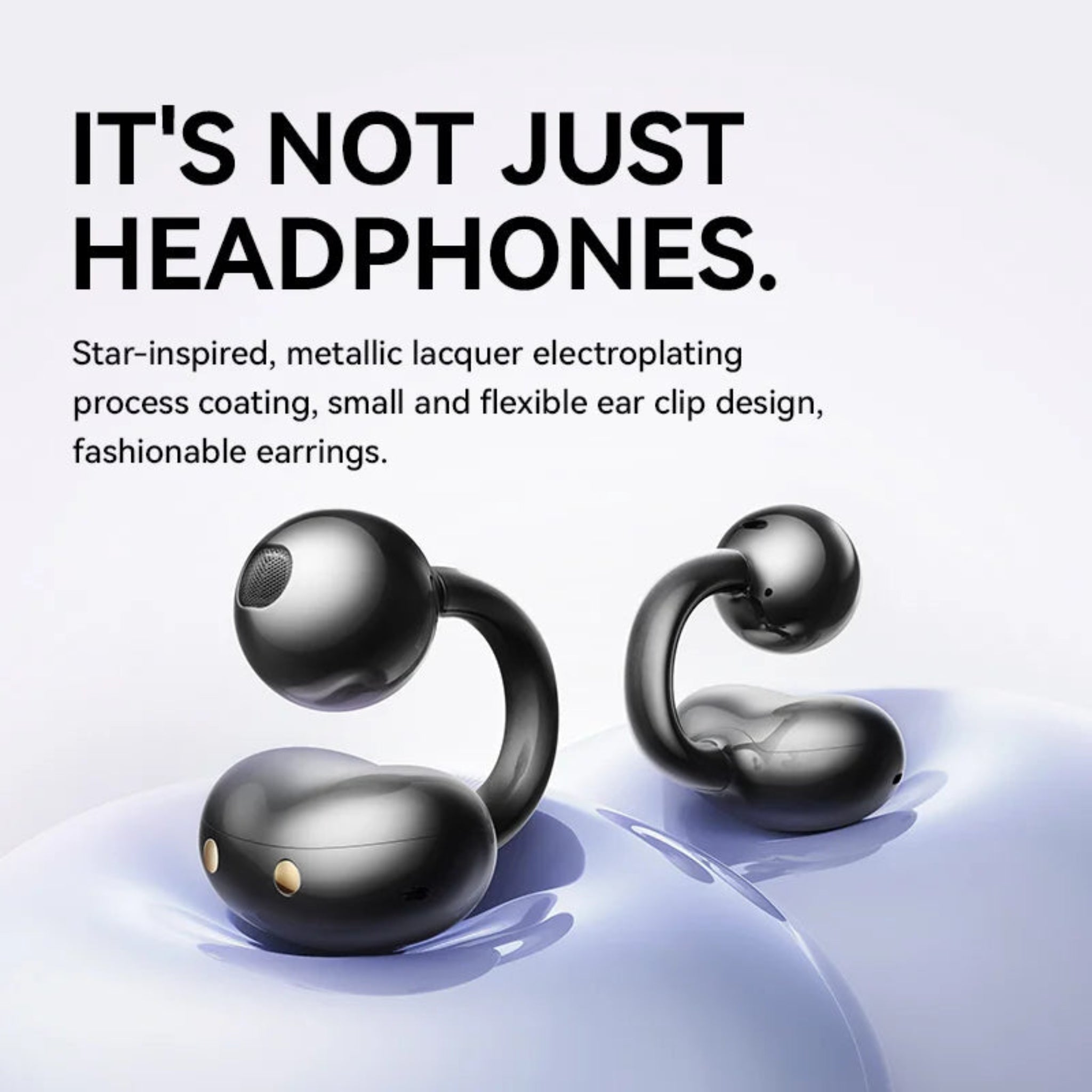 Black ear-shaped earrings with metallic finish on a light gray background