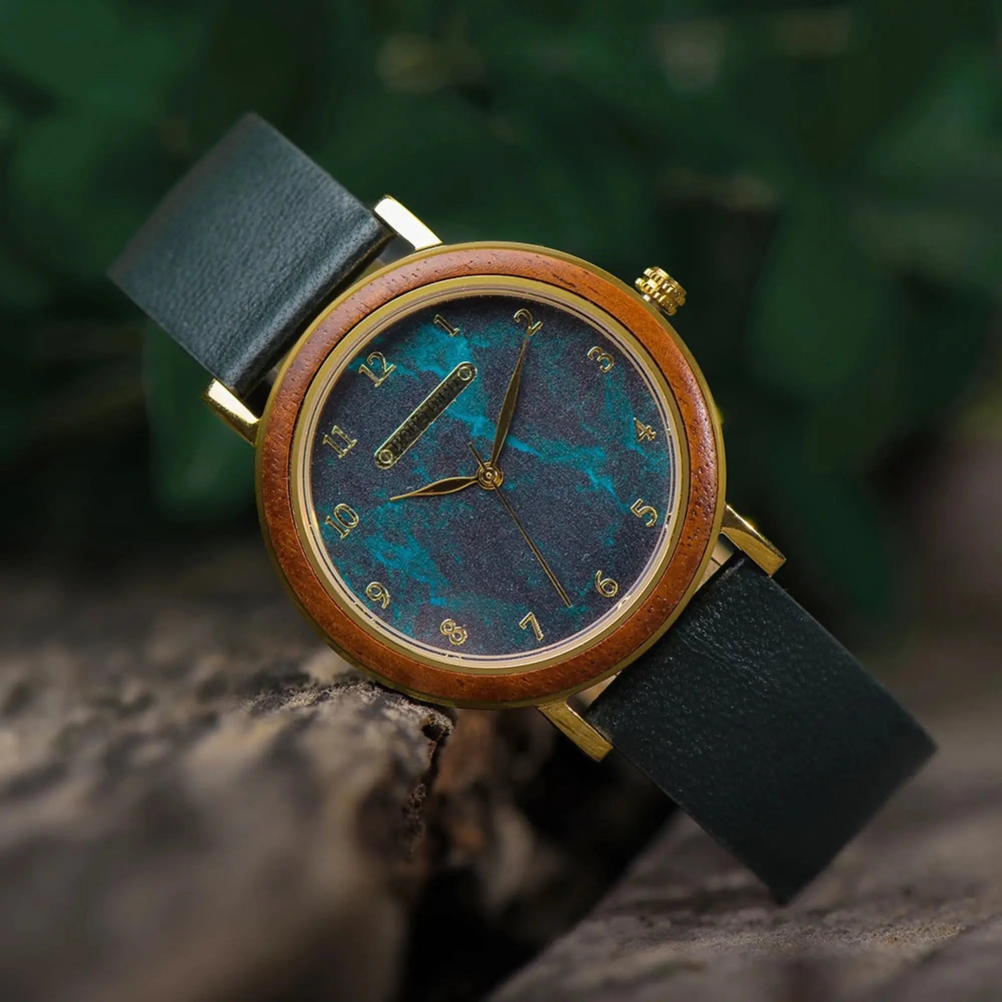 Watch with a blue face and black strap on a stone surface