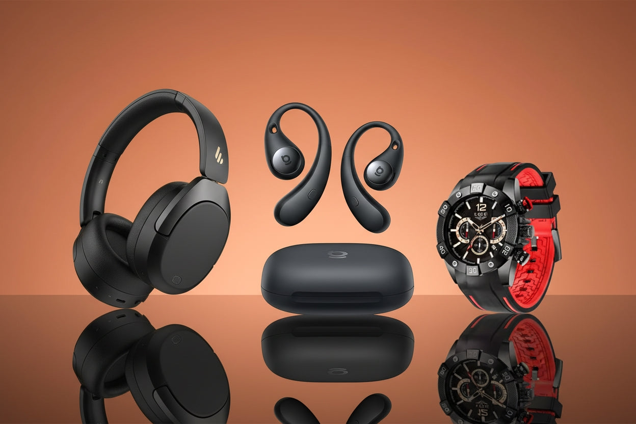 Black headphones, wireless earbuds, charging case, and black watch with red accents on a brown background