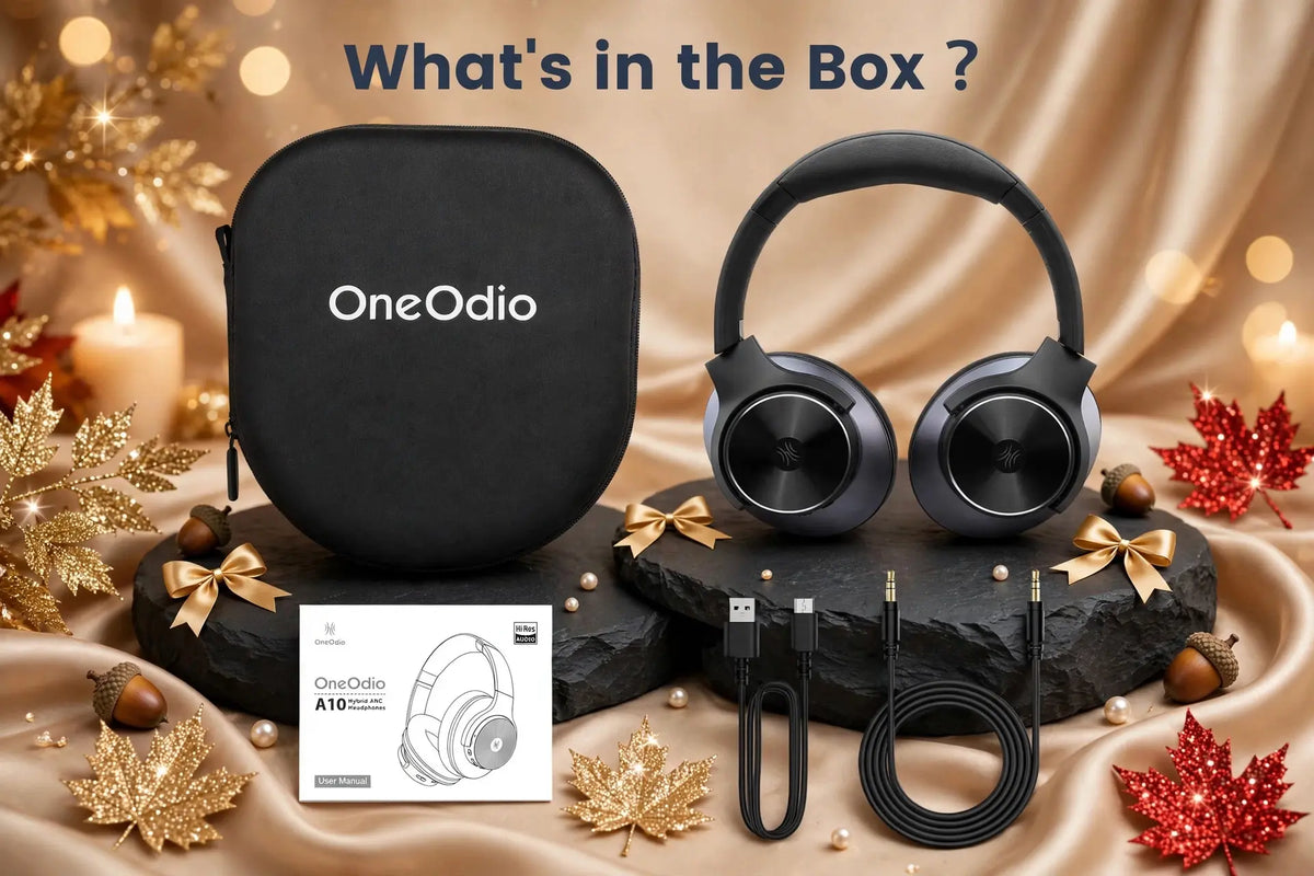 OneOdio A10 whats in the box showing black carrying case, headphones, user manual, USB cable and audio cable on black slate with champagne satin, gold bows and glitter leaves