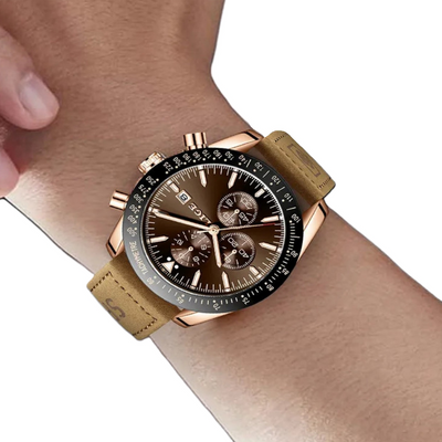Rose gold watch with brown leather strap on a wrist against a white background