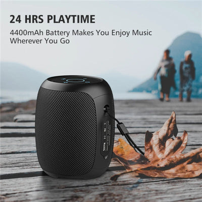 Black portable speaker with text about playtime and battery capacity, set against a scenic background.