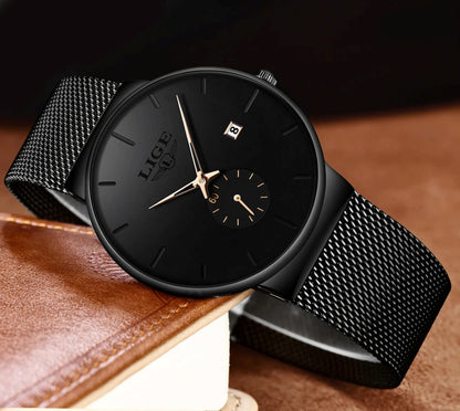 Black wristwatch with mesh band on a brown leather surface