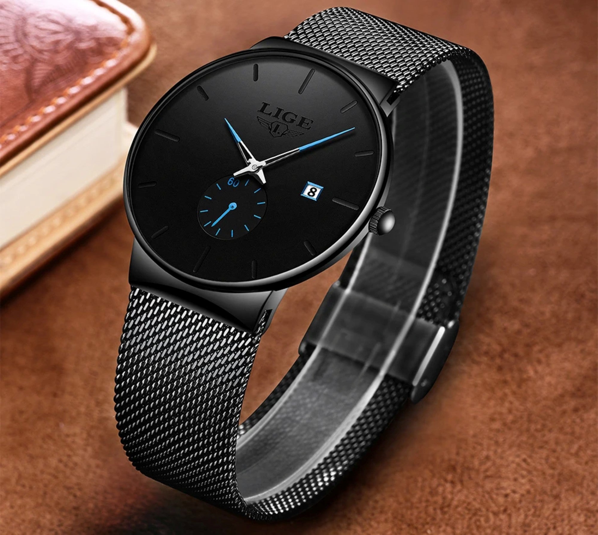 Black wristwatch with mesh band on a brown background