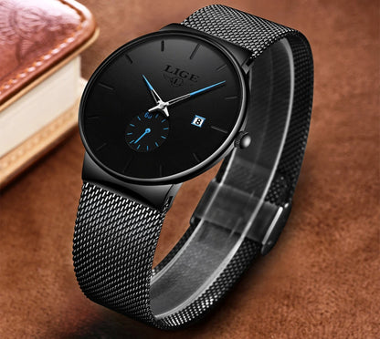 Black wristwatch with mesh band on a brown background