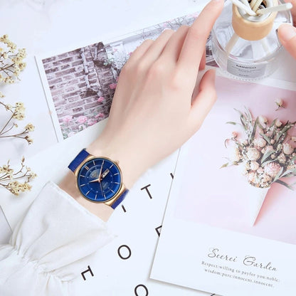 Hand wearing a blue watch on a decorative surface with flowers and cards