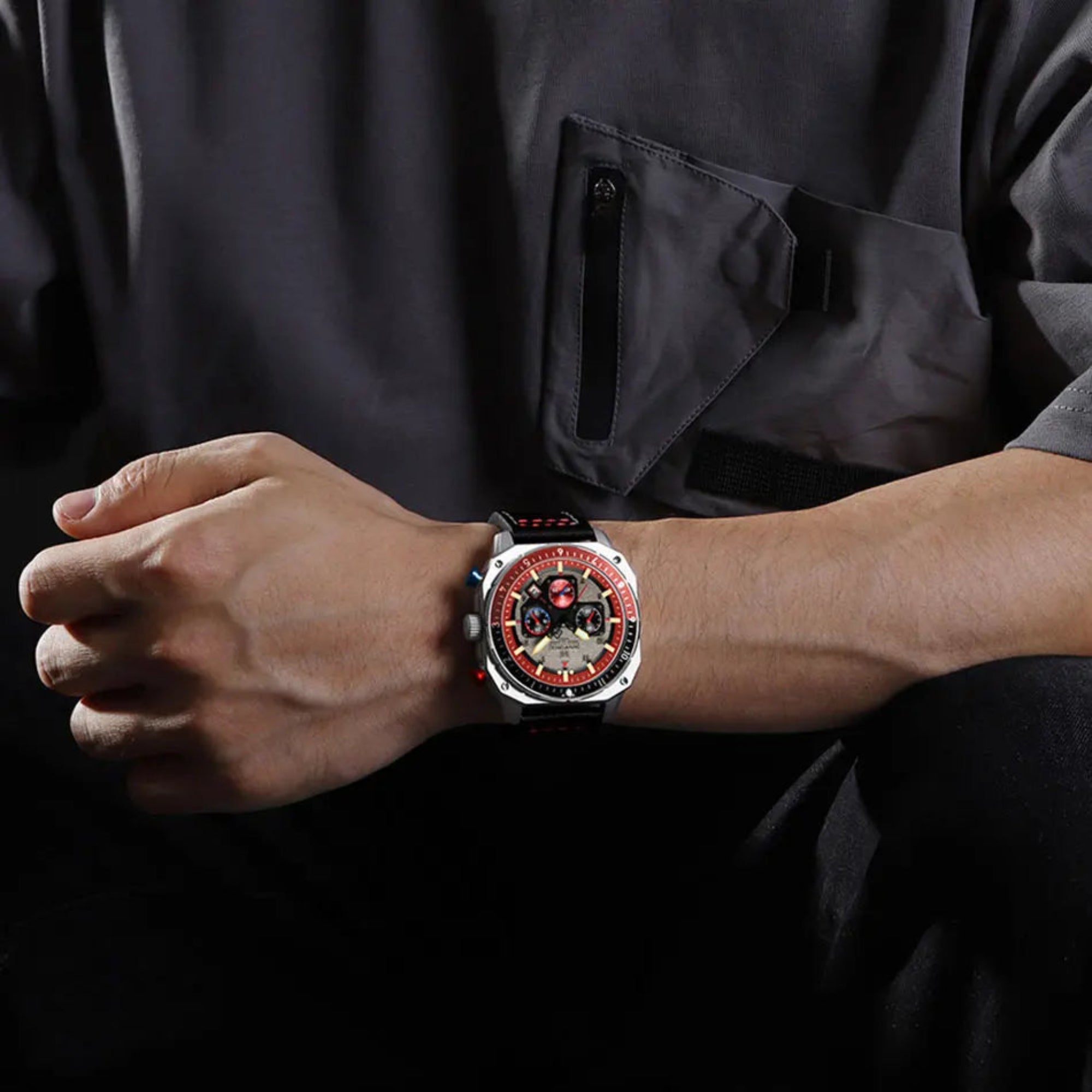 Person wearing a watch with a dark jacket and blurred background