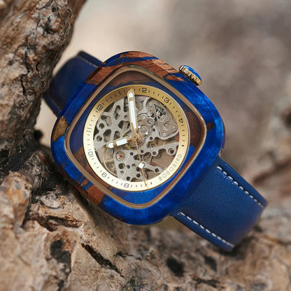 Luxury watch with blue strap and wooden accents on a textured surface