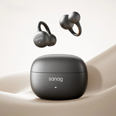 Black wireless earbuds with charging case on a beige surface
