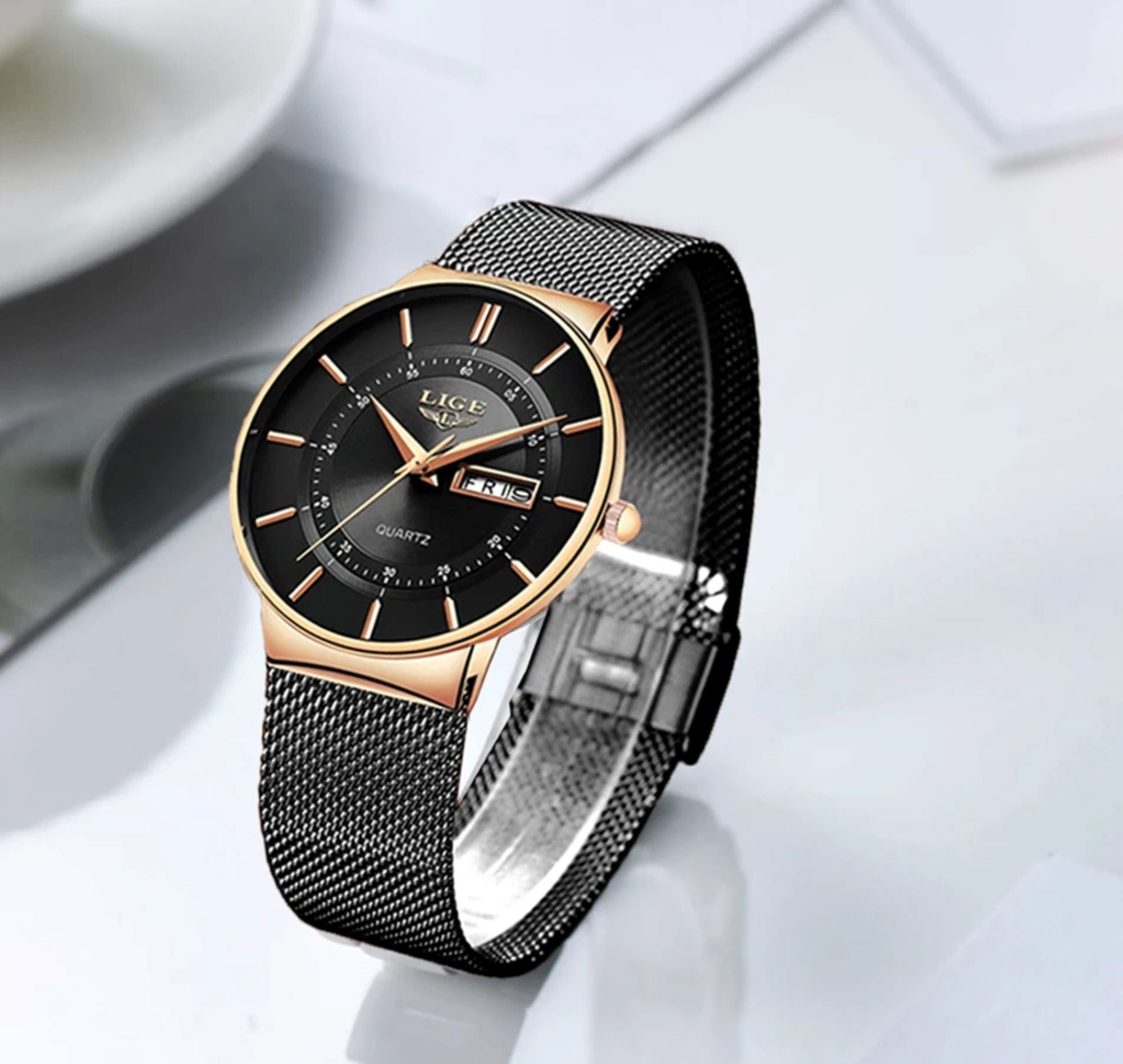 Luxury watch with black face and rose gold accents on a white background