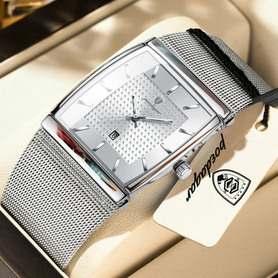 Silver watch with mesh band on a beige surface, brand tag visible