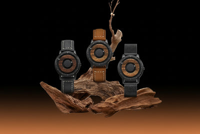 Three watches with wooden and leather accents on a natural wood display
