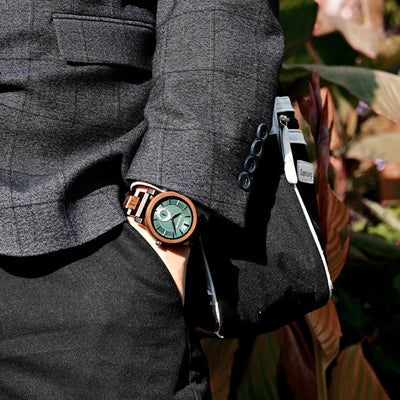 Person wearing a dark gray suit with a wooden watch on a blurred background