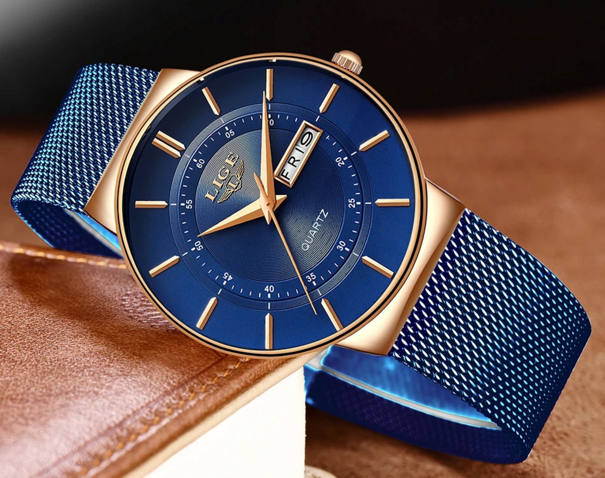 Blue watch with gold accents on a brown leather surface