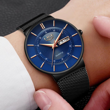 Blue watch with black mesh strap on a wrist against a neutral background