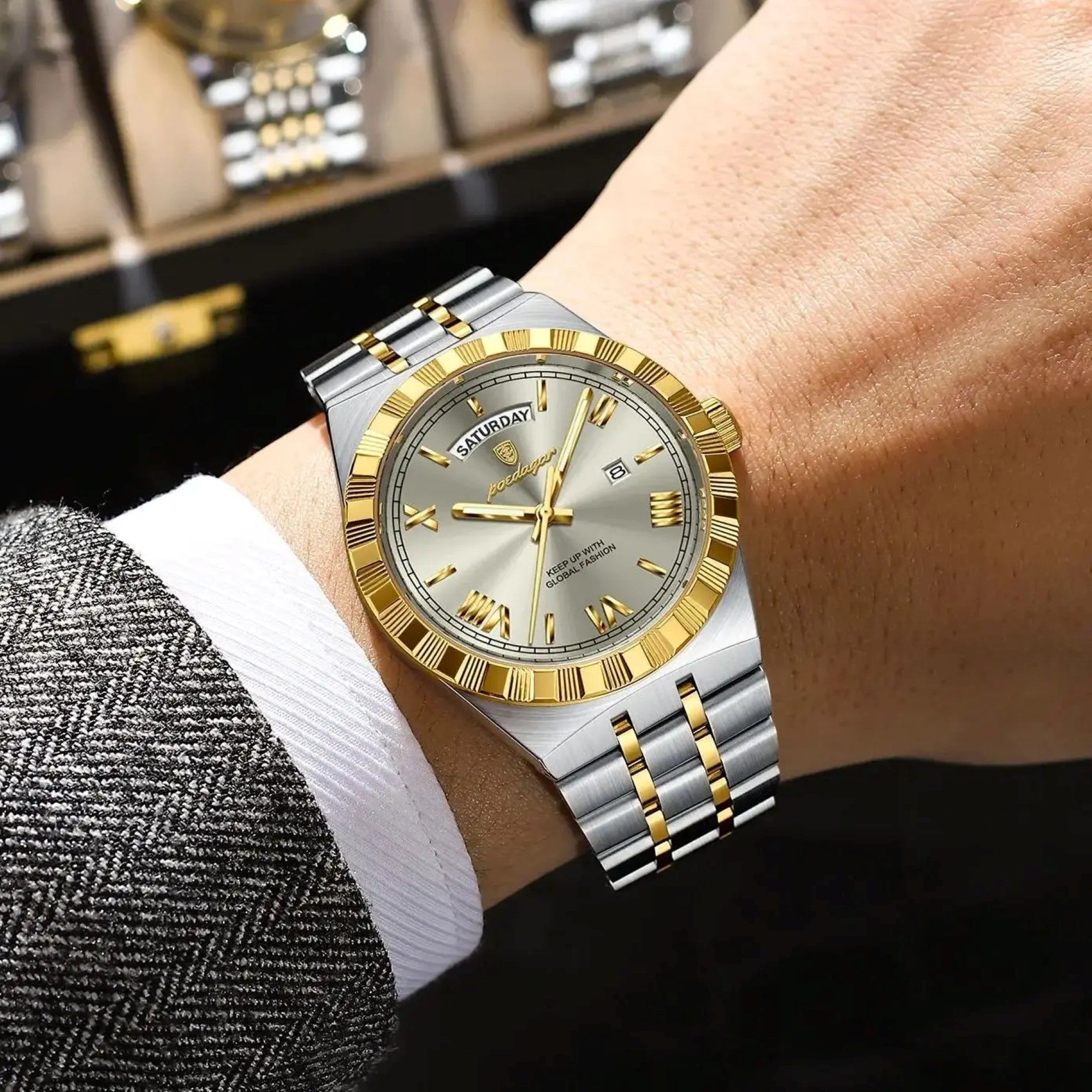Two-tone watch with silver and gold accents on a wrist, with a blurred background.