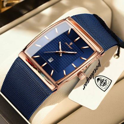 Luxury watch with blue strap and rose gold case on a beige surface, featuring a brand tag.