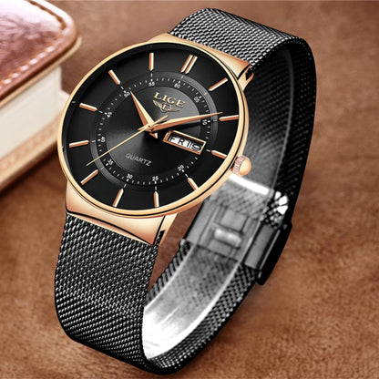 Black and gold watch with mesh band on a brown background