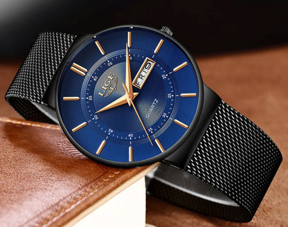 Watch with blue face and black mesh strap on a brown leather surface