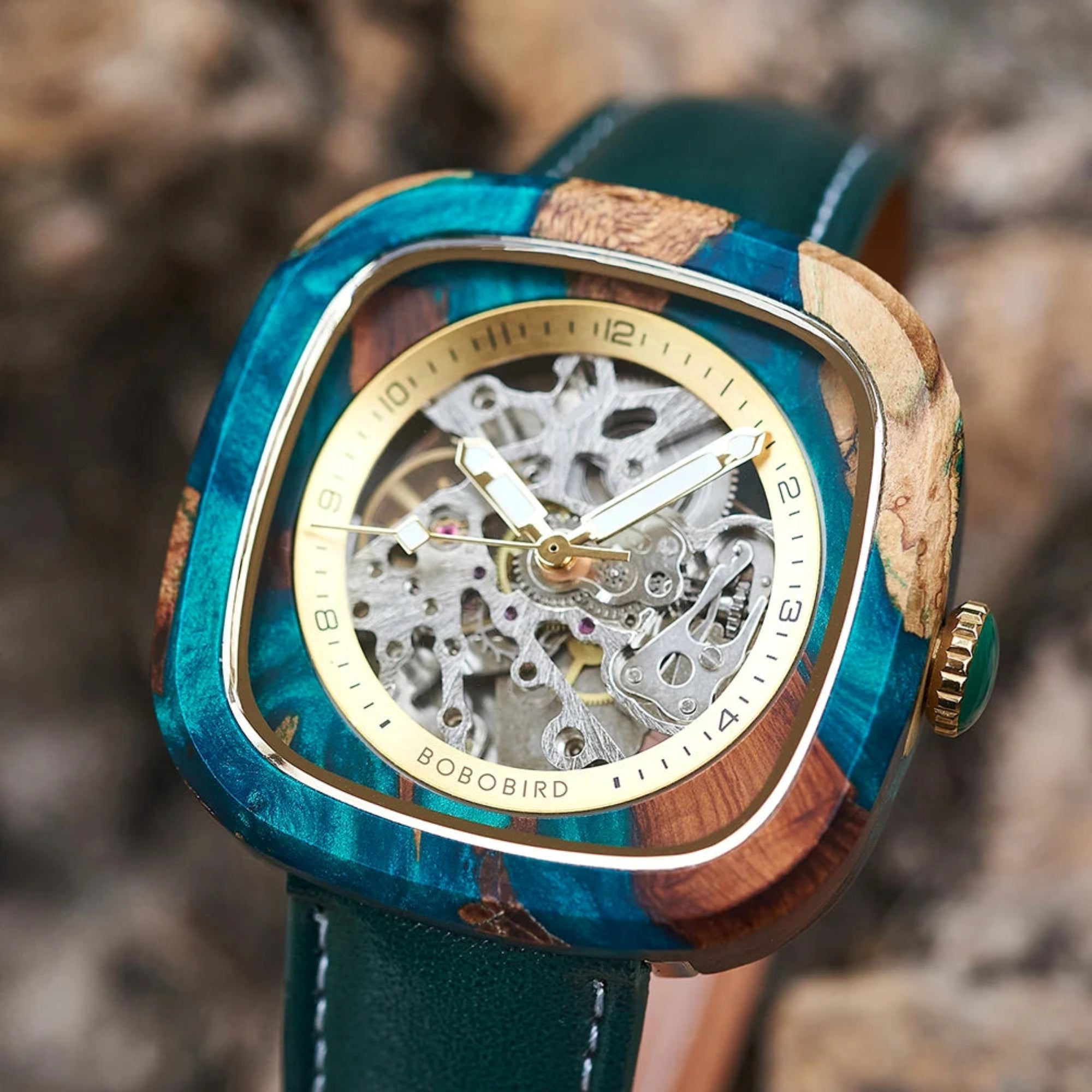 Wooden watch with blue and brown accents on a blurred natural 