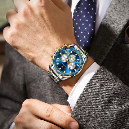 Close-up of a person wearing a blue and silver watch on a gray suit sleeve.