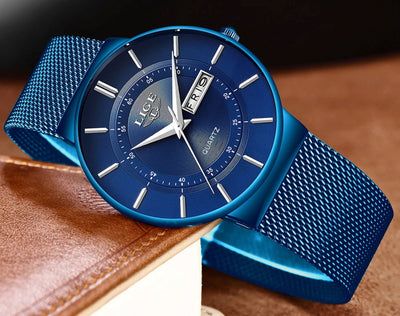 Blue wristwatch with mesh band on a brown leather surface