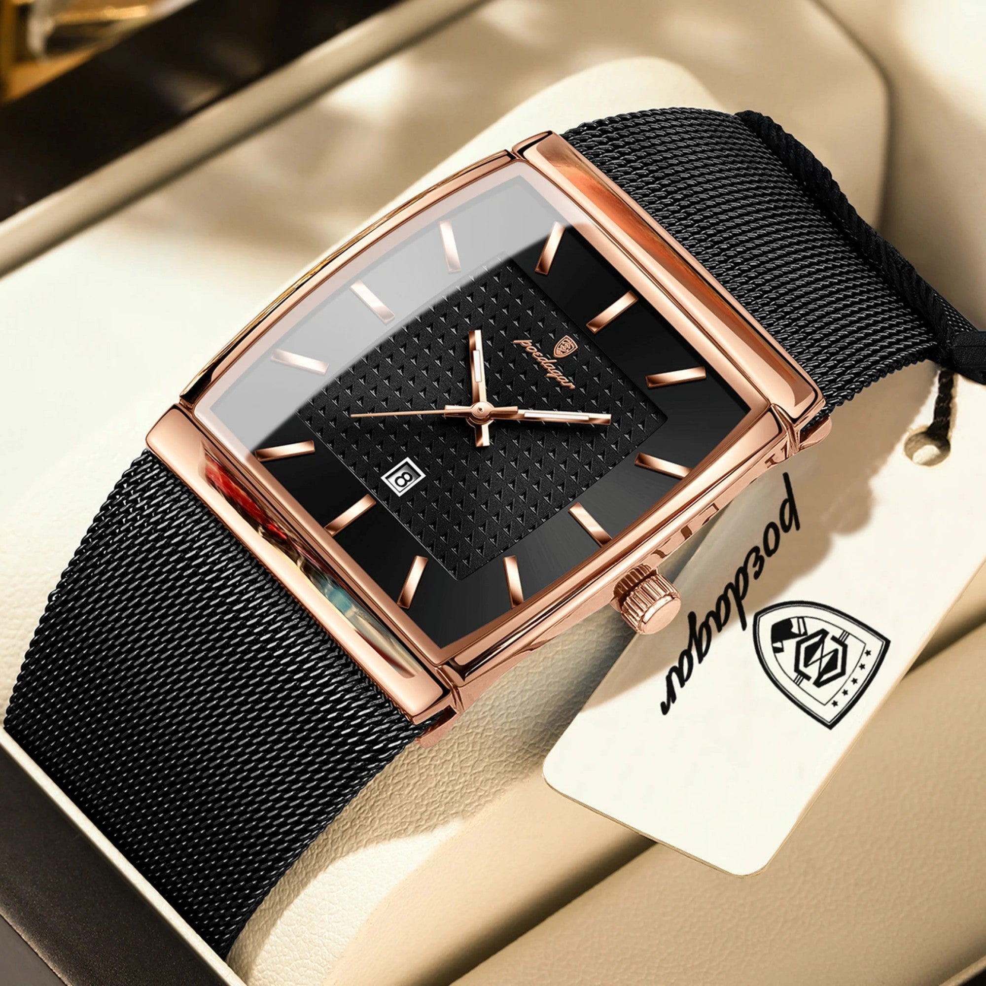 Luxury watch with black mesh strap and rose gold casing on a beige surface, featuring the brand name on a tag.