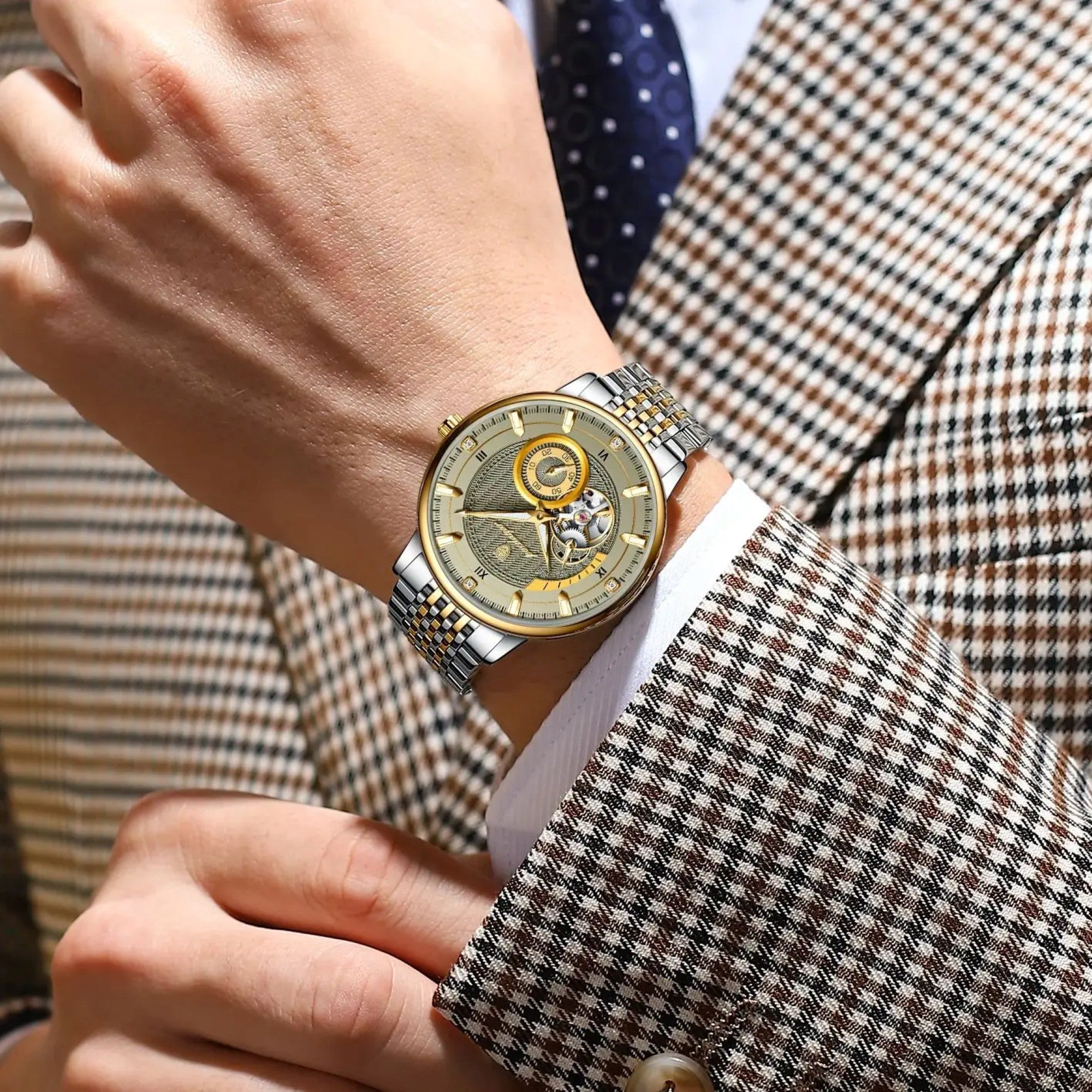 Close-up of a person wearing a gold wristwatch with a detailed face, dressed in a checkered suit.