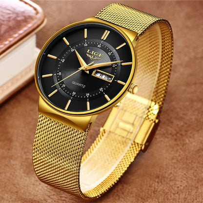 Gold wristwatch with black dial on a brown background