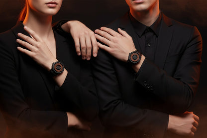 Two people wearing black suits with wooden watches on a dark background