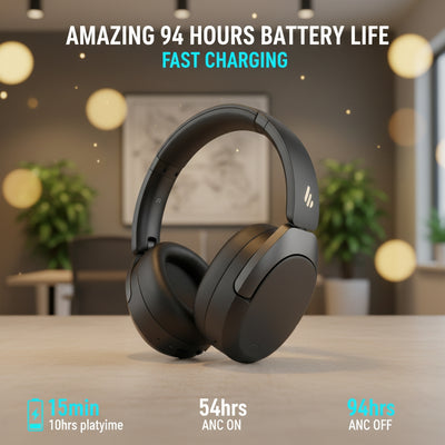 Black headphones on a table with battery life text and graphics in an indoor setting.