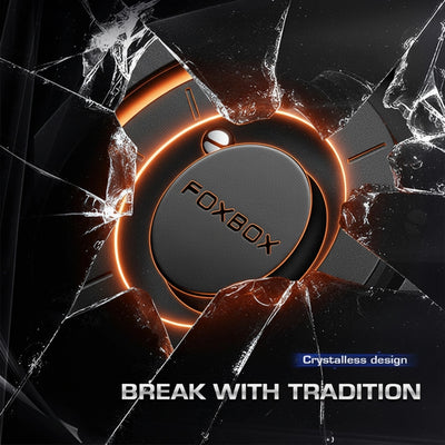 A circular black and dark gray product with the brand name FOXBOX on the center, surrounded by glowing orange rings and shown breaking through a cracked glass effect. Text at the bottom reads 'CRYSTALLESS DESIGN' and 'BREAK WITH TRADITION'.