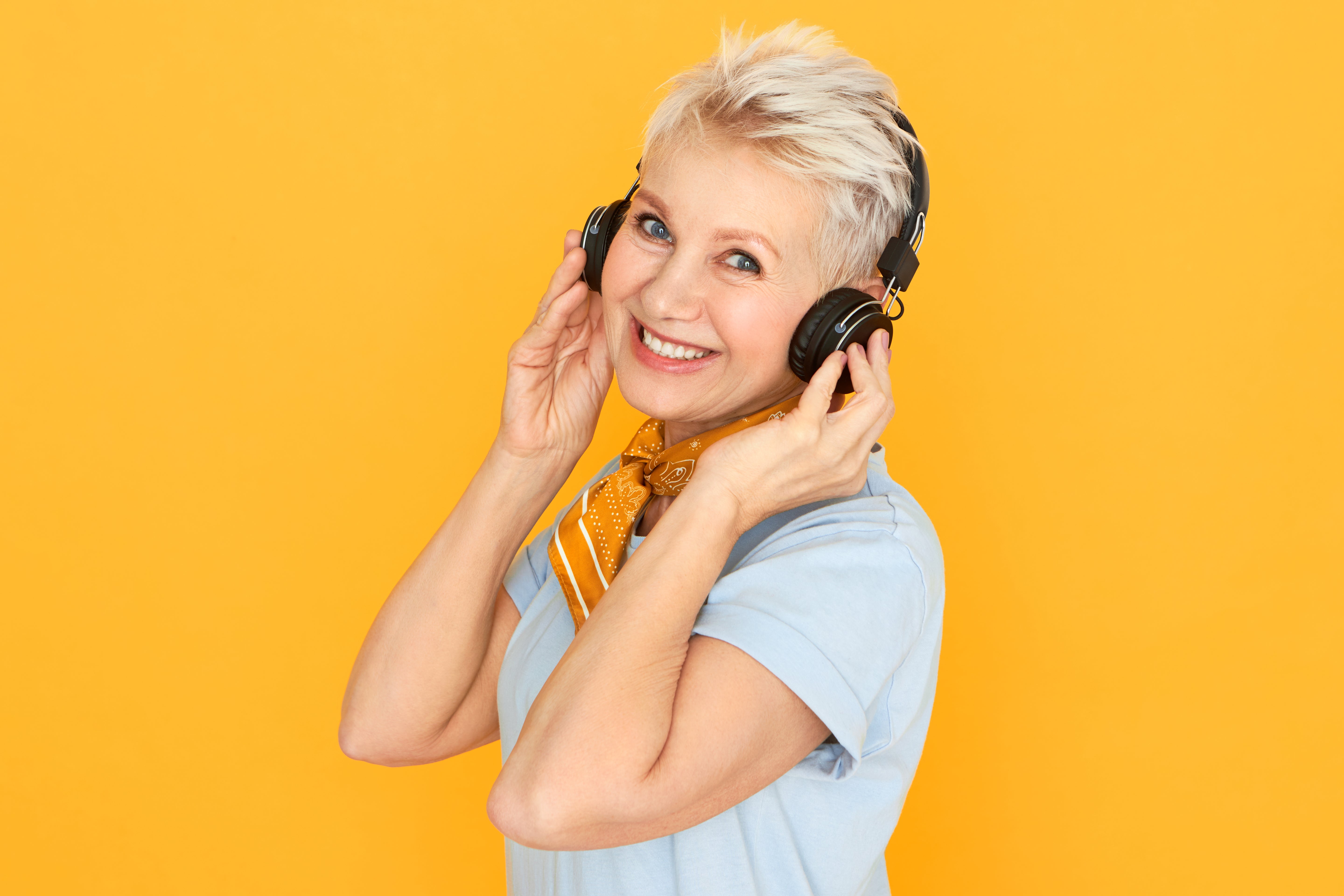 Woman wearing headphones on a yellow background